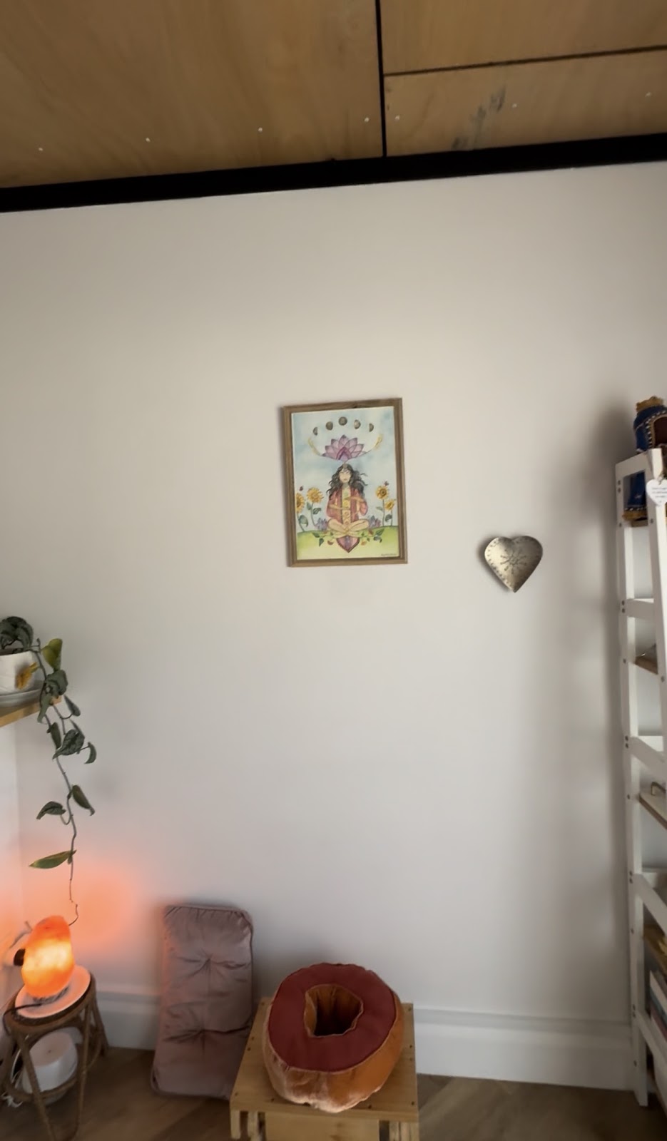 A quiet corner of the studio with floor cushions, a salt lamp and a framed painting
